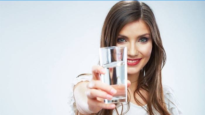 Naine hoiab klaasi vett
