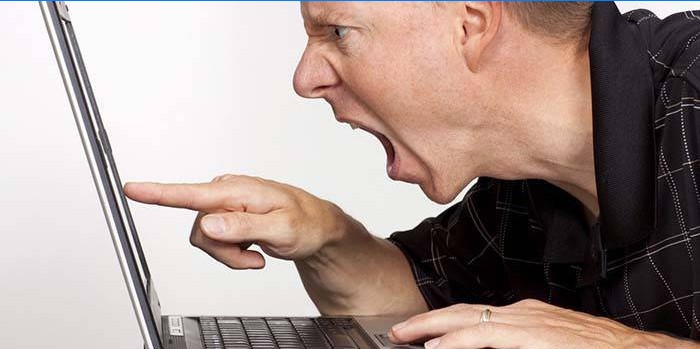 Vihane mees sülearvuti juures