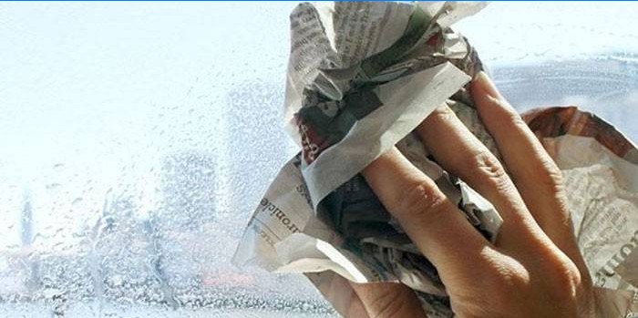 Inimene hõõrub ajalehega aknaklaasi
